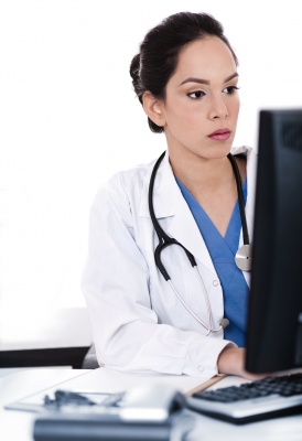 Charming doctor in the office behind the computer