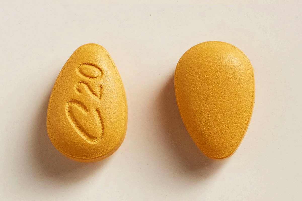 A close-up image of a yellow Cialis pill manufactured by Eli Lilly.