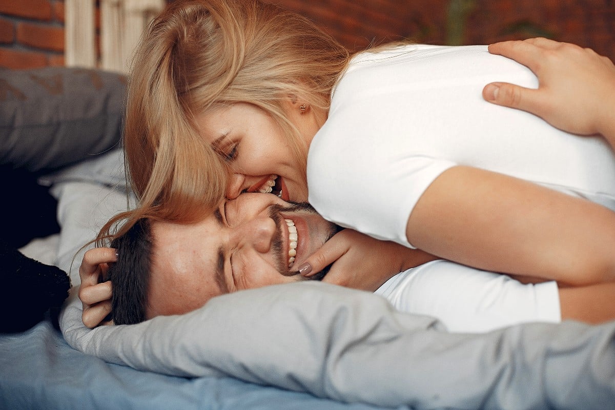 A happy couple in bed after having prolonged sex.