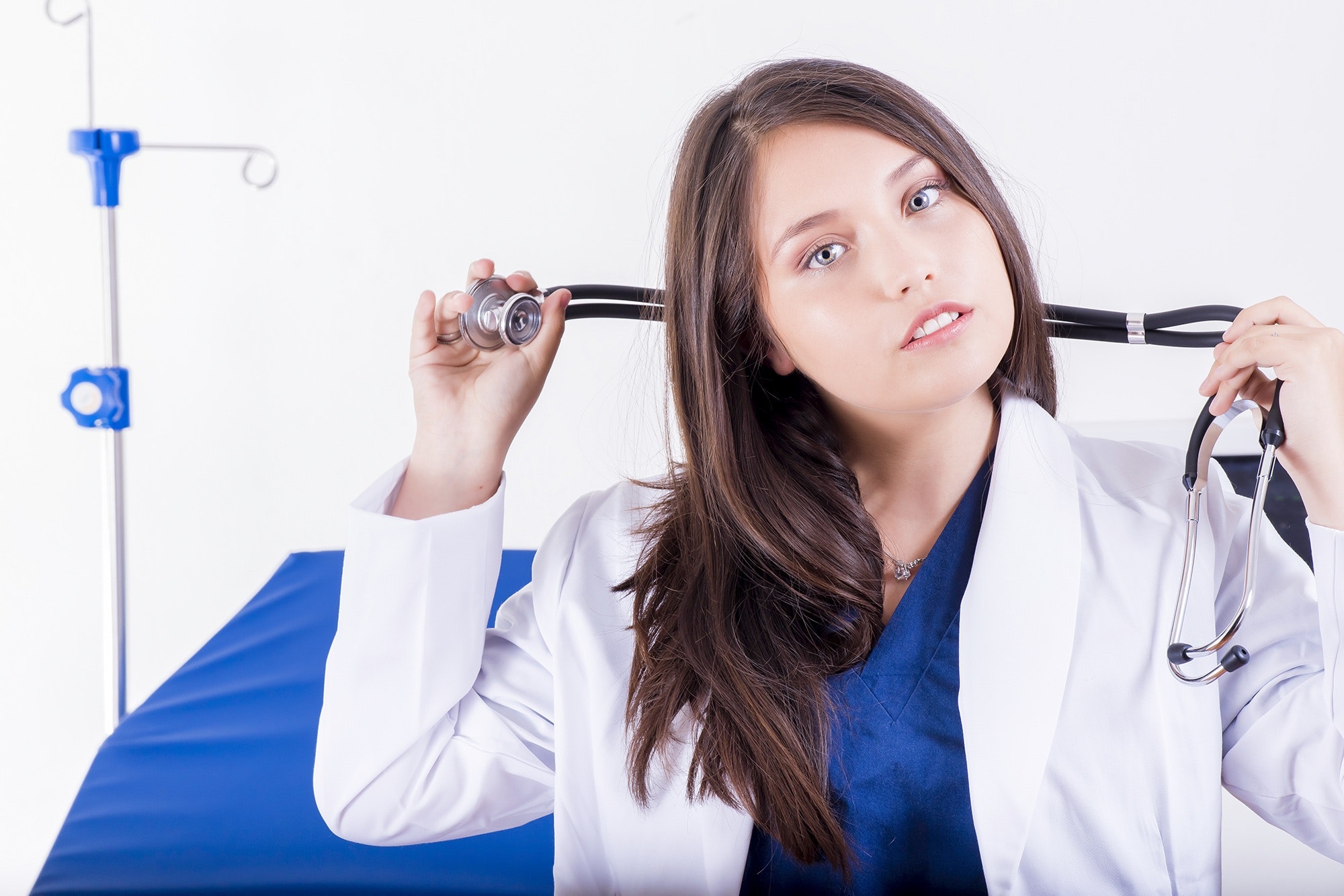 A doctor prepares her stethoscope to examine a patient